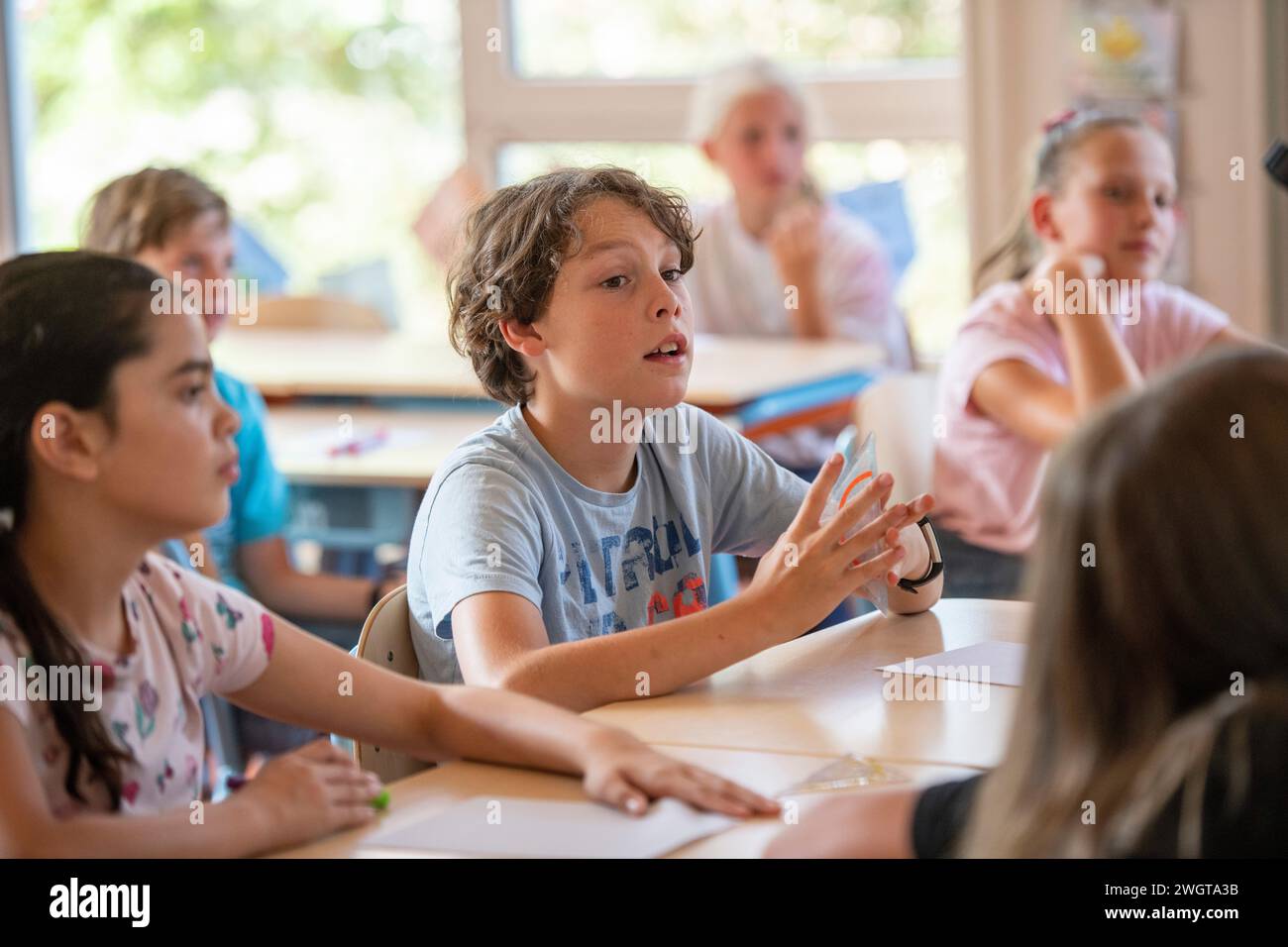 Junge in der Klasse, der die Lehrerfragen beantwortet Stockfoto