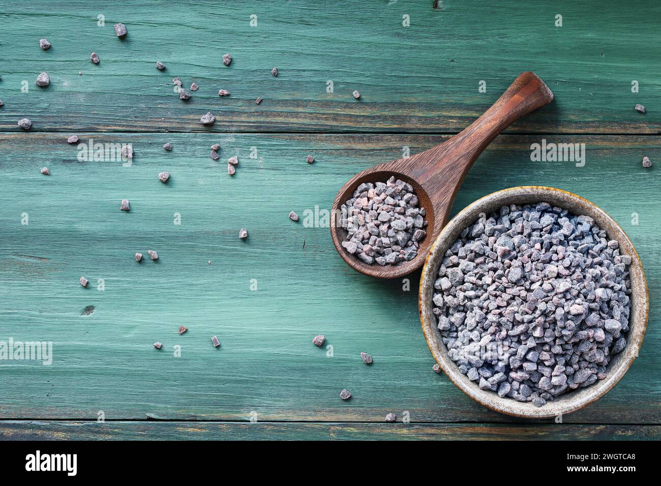 Von oben sehen Sie eine Schüssel mit Himalaya Black Salt oder Kala Namak, mit einem Holzlöffel. Flache Ansicht der Tischplatte. Stockfoto