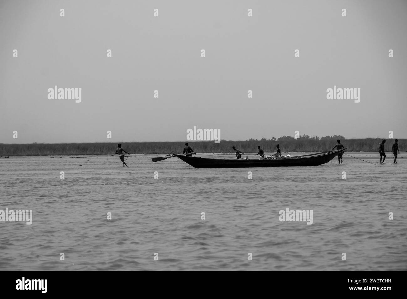 Eine Gruppe von Leuten rudert ein Boot im Fluss. Stockfoto