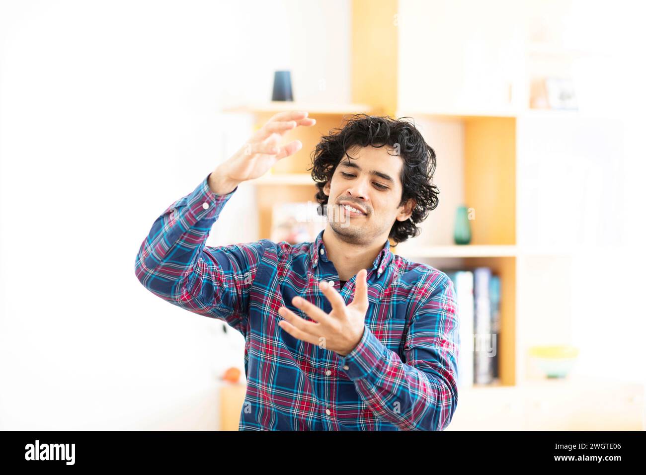 Junger Mann zu Hause, der mit den Händen Schilder macht Stockfoto