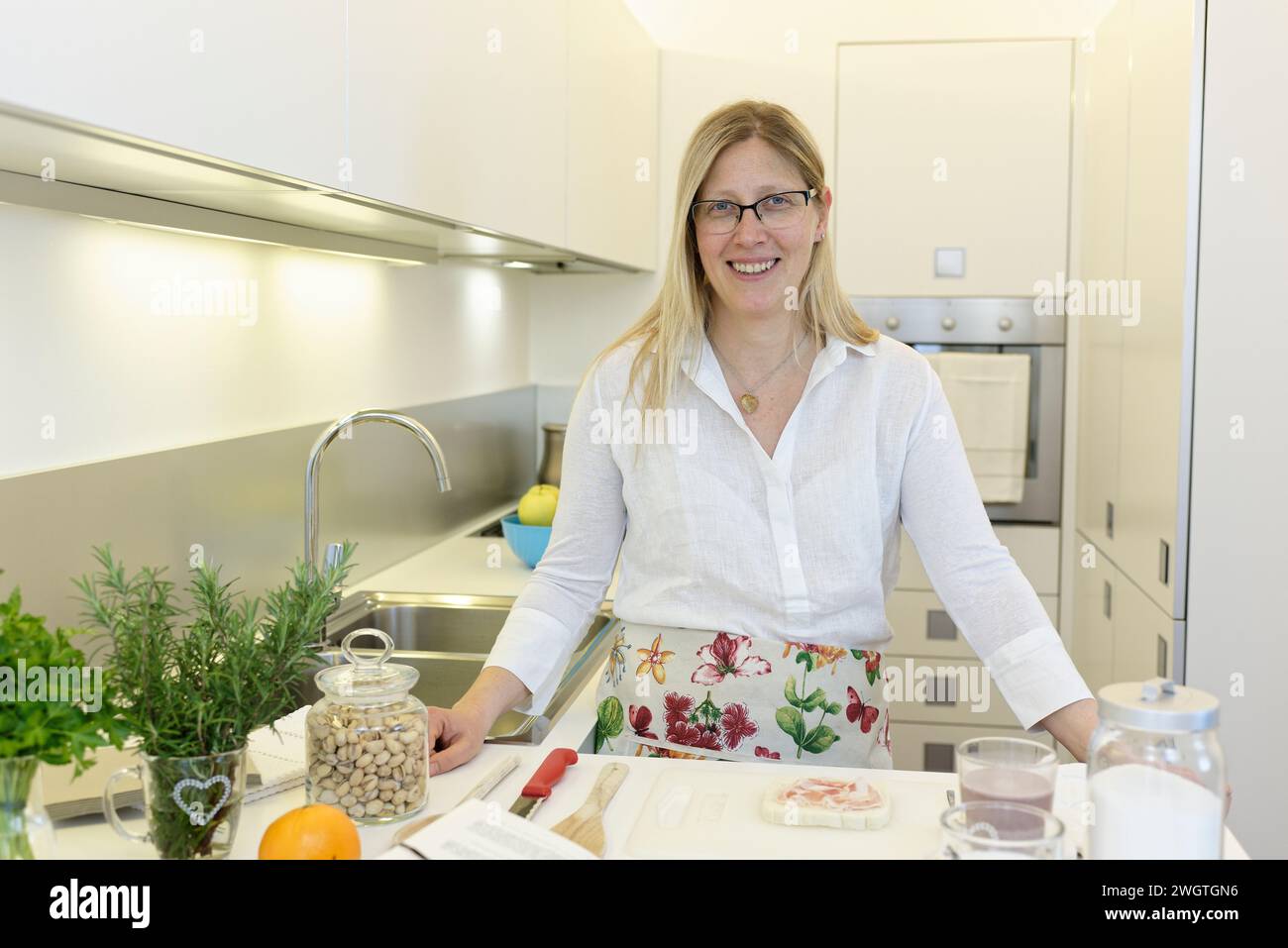 Blonde Frau, die drinnen kocht, Mailand, Italien. Stockfoto