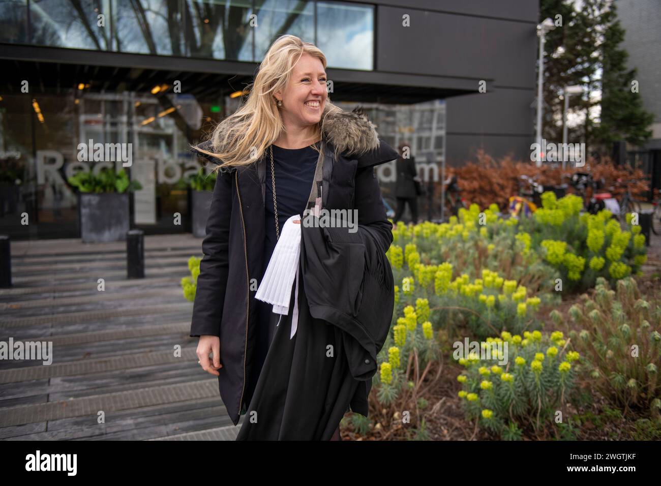 Junge Berufsfrau, die in der Öffentlichkeit steht und glücklich lächelt, zur Arbeit zu gehen Stockfoto