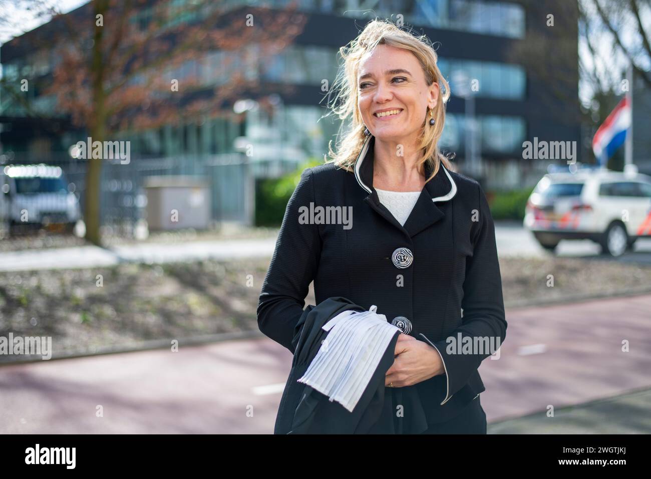 Junge Berufsfrau, die in der Öffentlichkeit steht und glücklich lächelt, zur Arbeit zu gehen Stockfoto