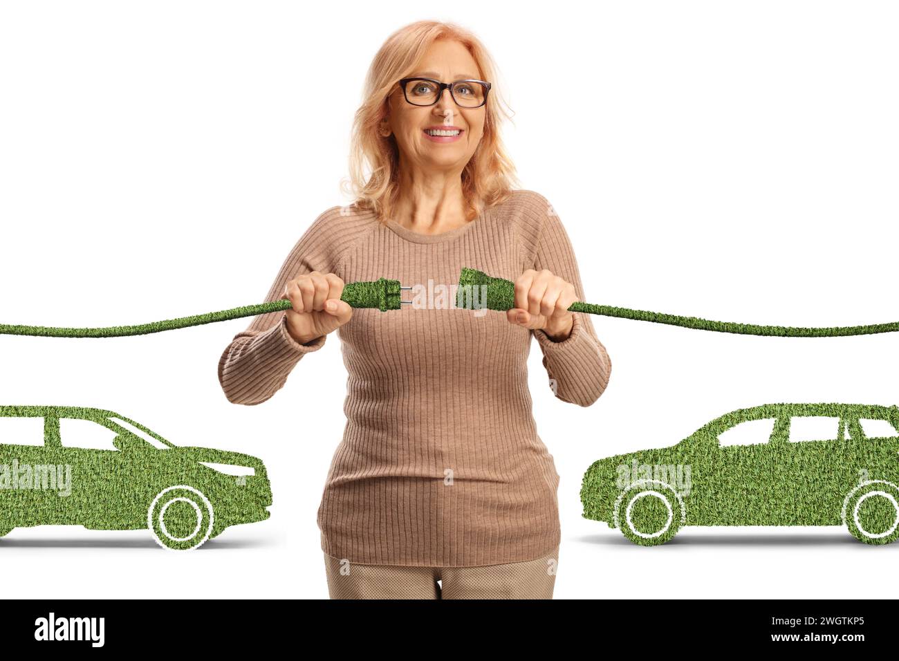Glückliche reife Frau, die grüne Elektrokabel für Elektrofahrzeuge auf weißem Hintergrund einsteckt Stockfoto