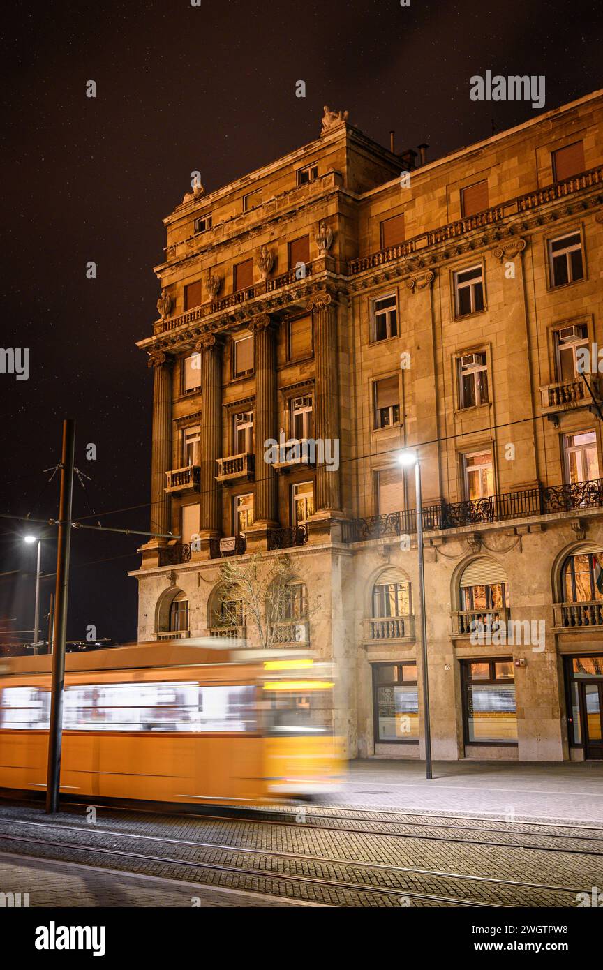 Die Straßenbahn fährt vor dem Gebäude Stockfoto