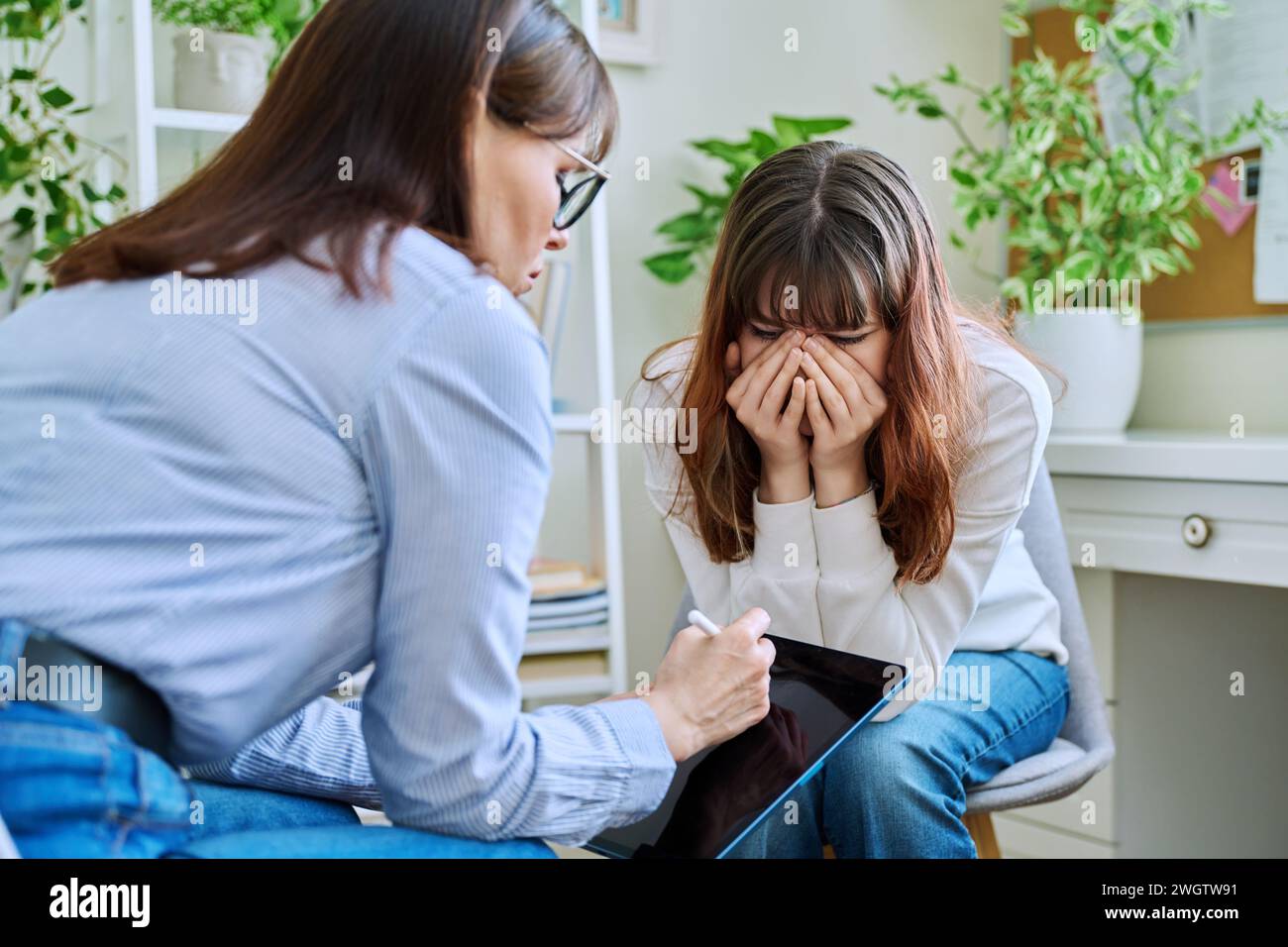 Trauriges, weinendes Teenager-Mädchen bei der Sitzung im Büro des Psychologen Stockfoto