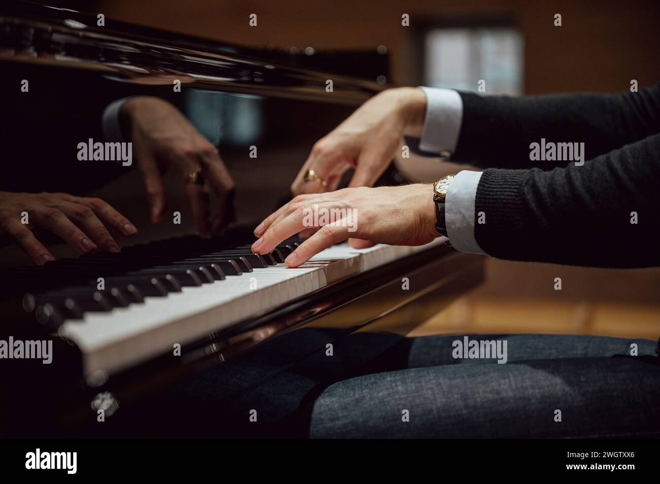 Niedriger Blickwinkel auf die Hände eines professionellen Pianisten, der in einem Konzert oder einer Vorstellung Klavier spielt. Stockfoto