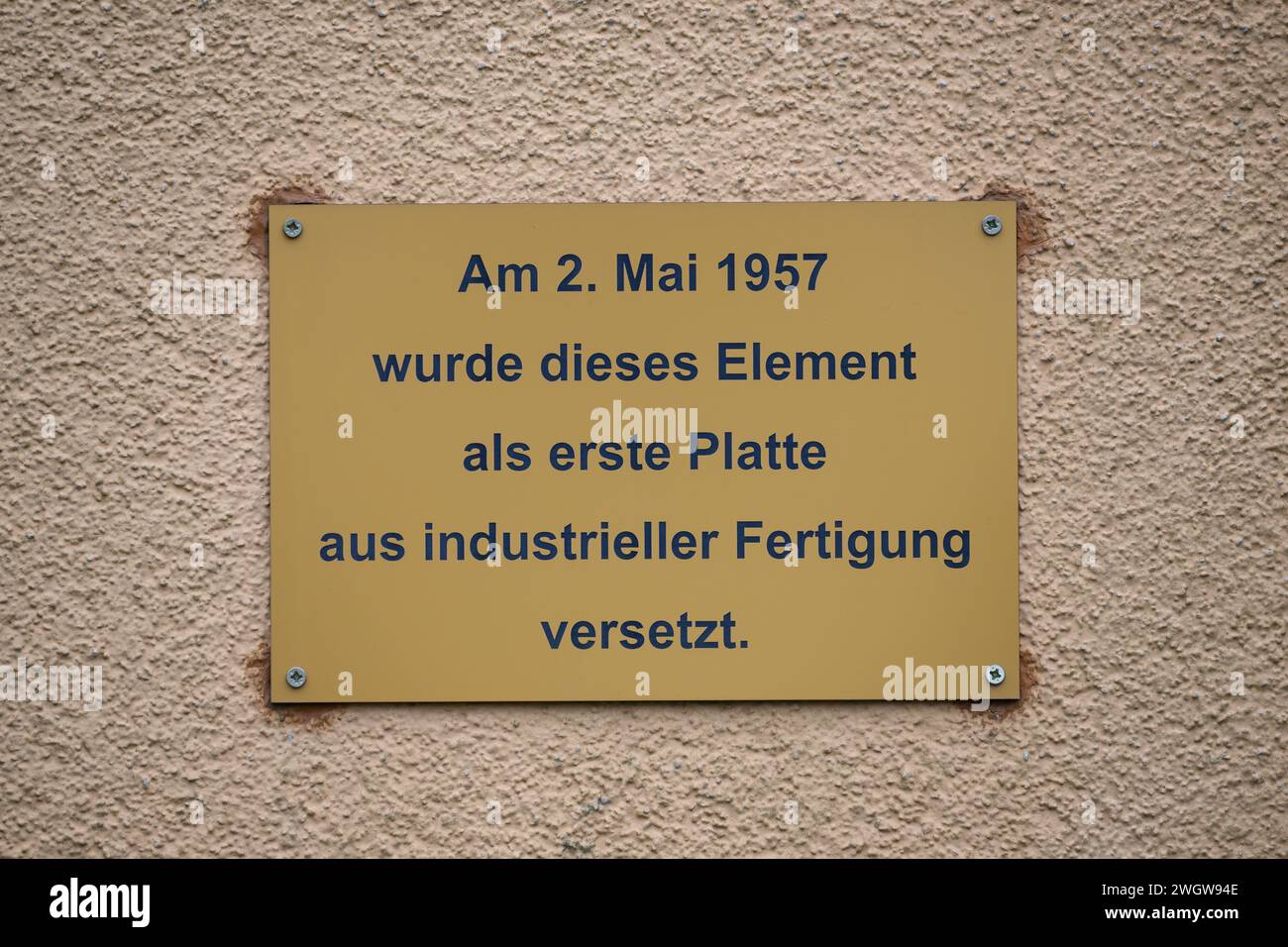Hoyerswerda, Deutschland. Februar 2024. An der Fassade eines denkmalgeschützten Wohnblocks in der Konrad-Zuse-Straße im Wohnkomplex I (WK I) befindet sich ein Schild mit der Aufschrift „am 2. Mai 1957 wurde dieses Element als erste Platte aus der industriellen Produktion verlegt“. Der kommunale Wohnungsbauverband plant den Abriss von zwei Wohnblöcken im Stadtteil. Robert Michael/dpa/Alamy Live News Stockfoto