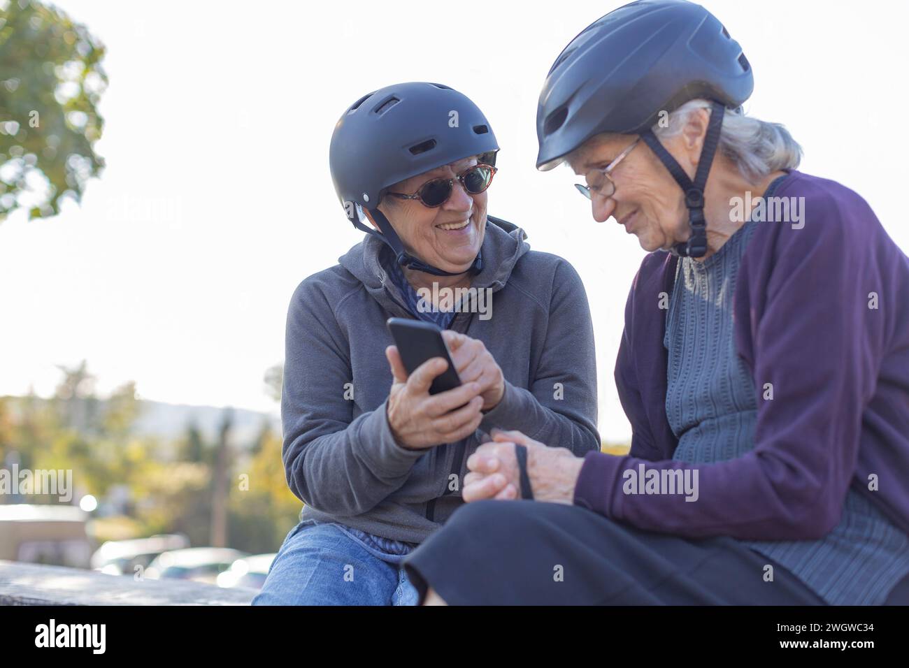 Zwei ältere Damen sitzen mit Fahrradhelmen Stockfoto