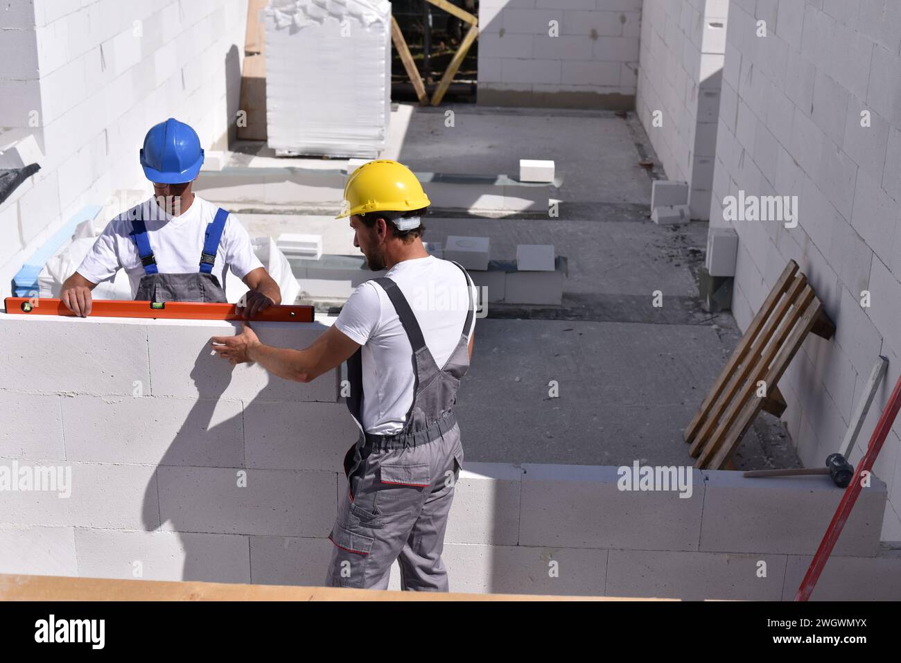 Teamwork auf der Baustelle - Bauarbeiter bauen ein Haus der Familie Stockfoto