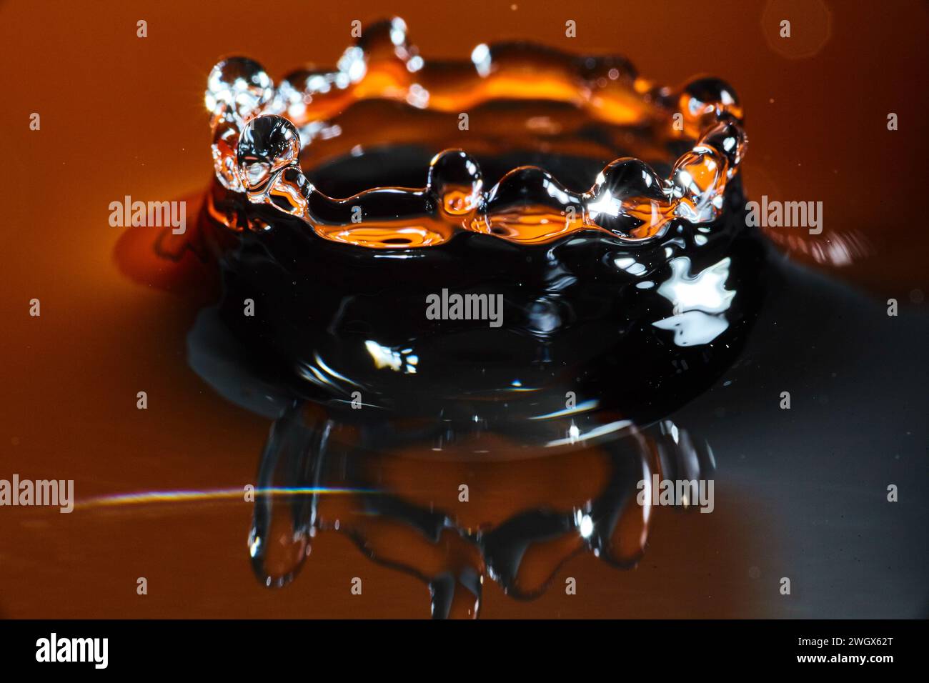 Elegante Wasserspritzkrone Vor Warmem Hintergrund Stockfoto
