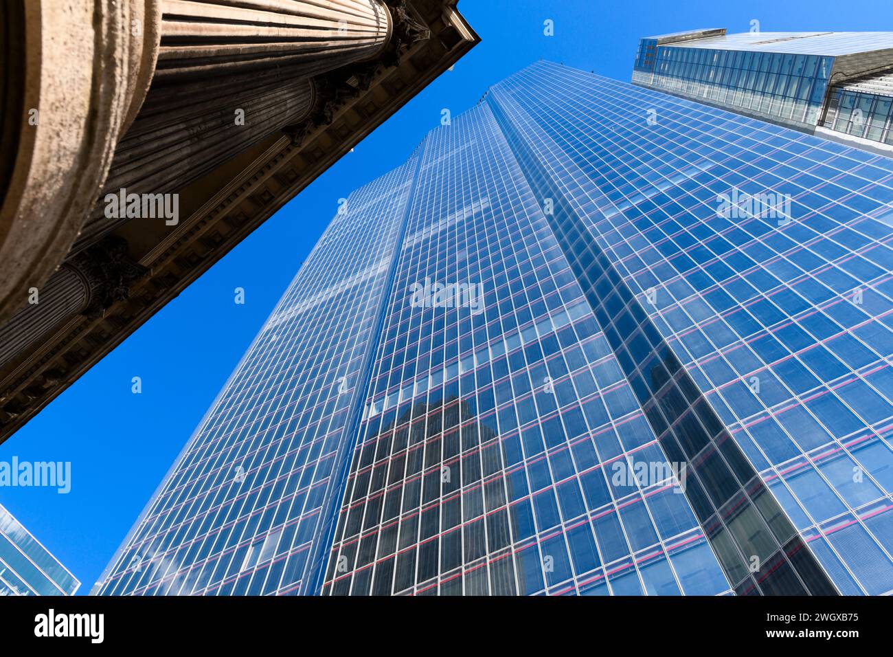 Der 22 Hochhaus von Bishopsgate ragt über den korinthischen Säulen der Gibson Hall. Zweiundzwanzig Bishopsgate, City of London, Großbritannien. April 2023 Stockfoto