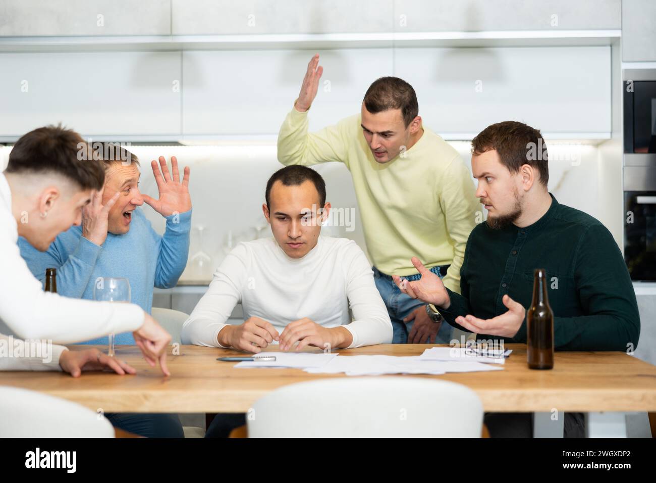 Eine Gruppe von Männern, die einen beunruhigten Freund beim Lesen rechtlicher Hinweise unterstützen Stockfoto