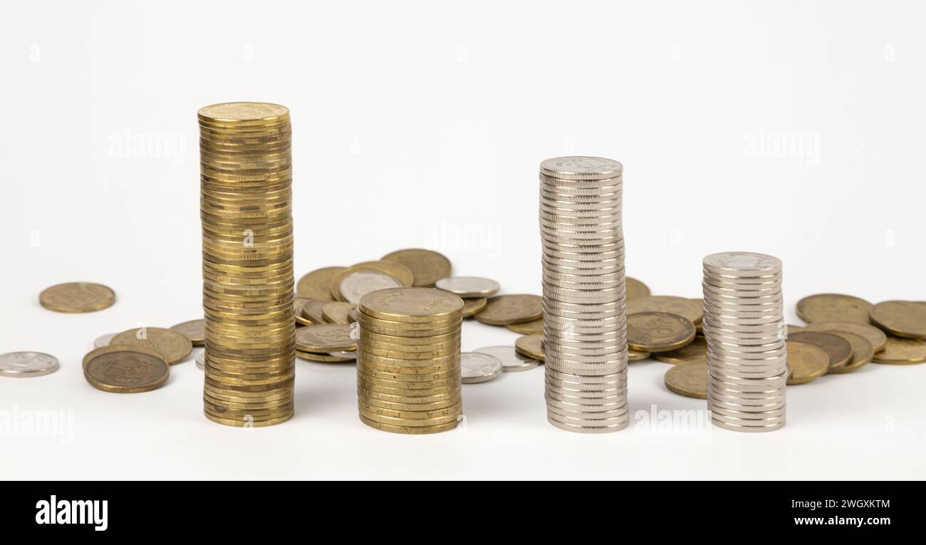 Münzhaufen auf weißem Hintergrund, verstreute Münzen dahinter. Grafik der Münzen, ukrainische Griwna. Das Konzept des Sparens. Stockfoto