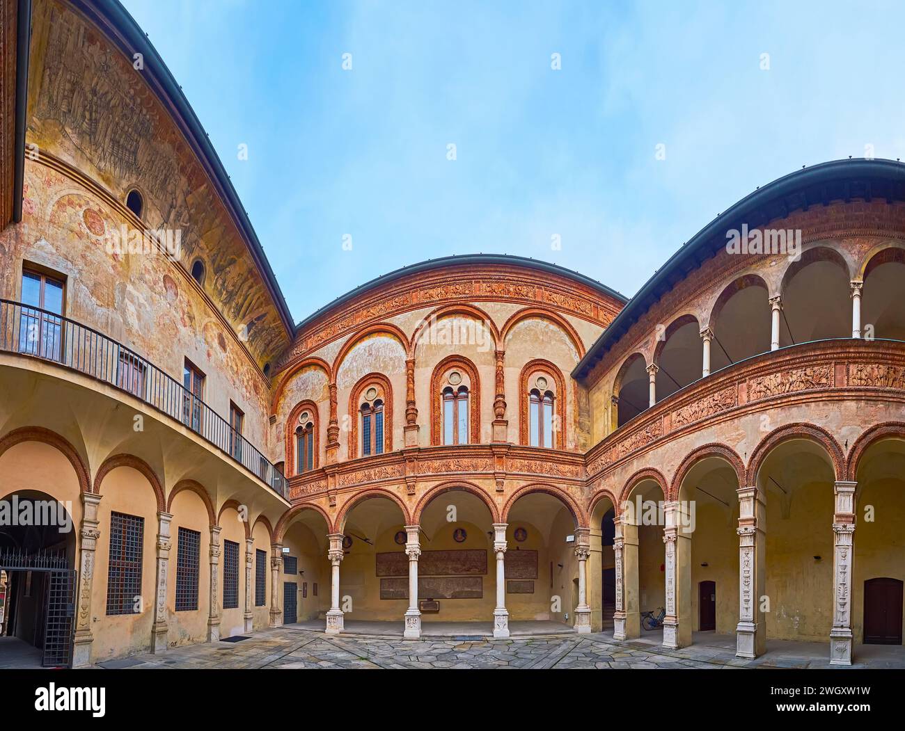 CREMONA, ITALIEN - 6. APRIL 2022: Der malerische mittelalterliche Innenhof des Palazzo Fodri (Fodri-Palast) mit erhaltenen Fresken und Arkaden mit geschnitztem Stein Stockfoto