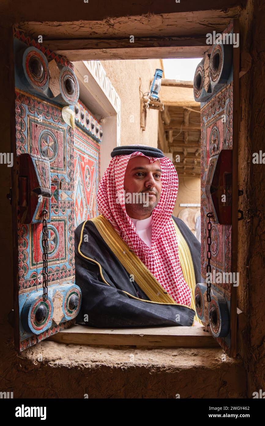 Naher Osten, Saudi-Arabien, Riad. November 2023. Saudischer Mann in einem bunt bemalten Fenster im Dorf Najd. Stockfoto