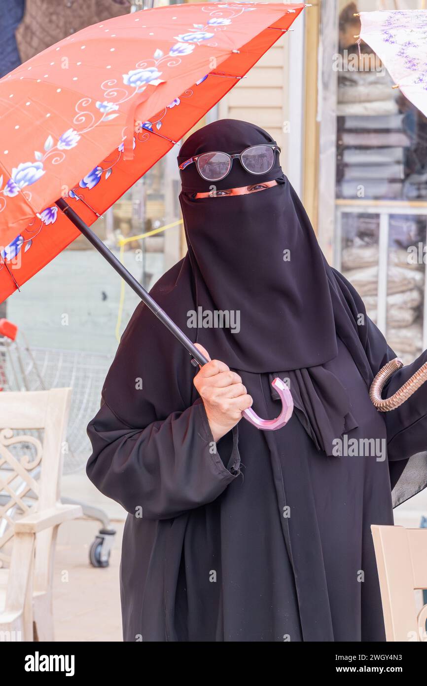 Naher Osten, Saudi-Arabien, Riad, Al-Dirah. November 2023. Frau mit einem Schirm im Souq Al-Zal. Stockfoto