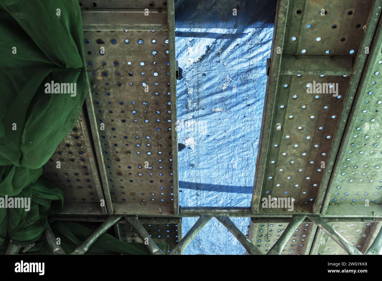 Gebäude, das einer Fassadensanierung unterzogen wird, mit Schutzplanen überzogenen Metallgerüsten Stockfoto