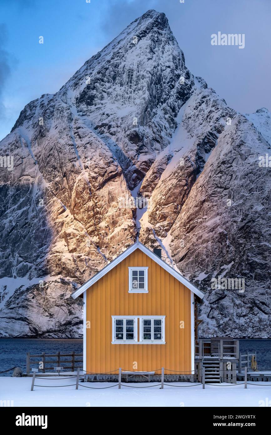 Gelbe Hütte im Winter vom Berg Olstinden, Dorf Sakrisøy, Gemeinde Moskenes, Landkreis Nordland, Lofoten Inseln, Norwegen Stockfoto