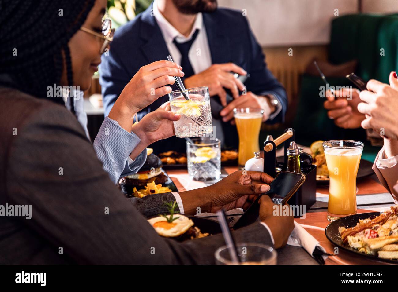 Hände von Geschäftsleuten, die in einem Restaurant zu einem Geschäftsessen sitzen. Stockfoto