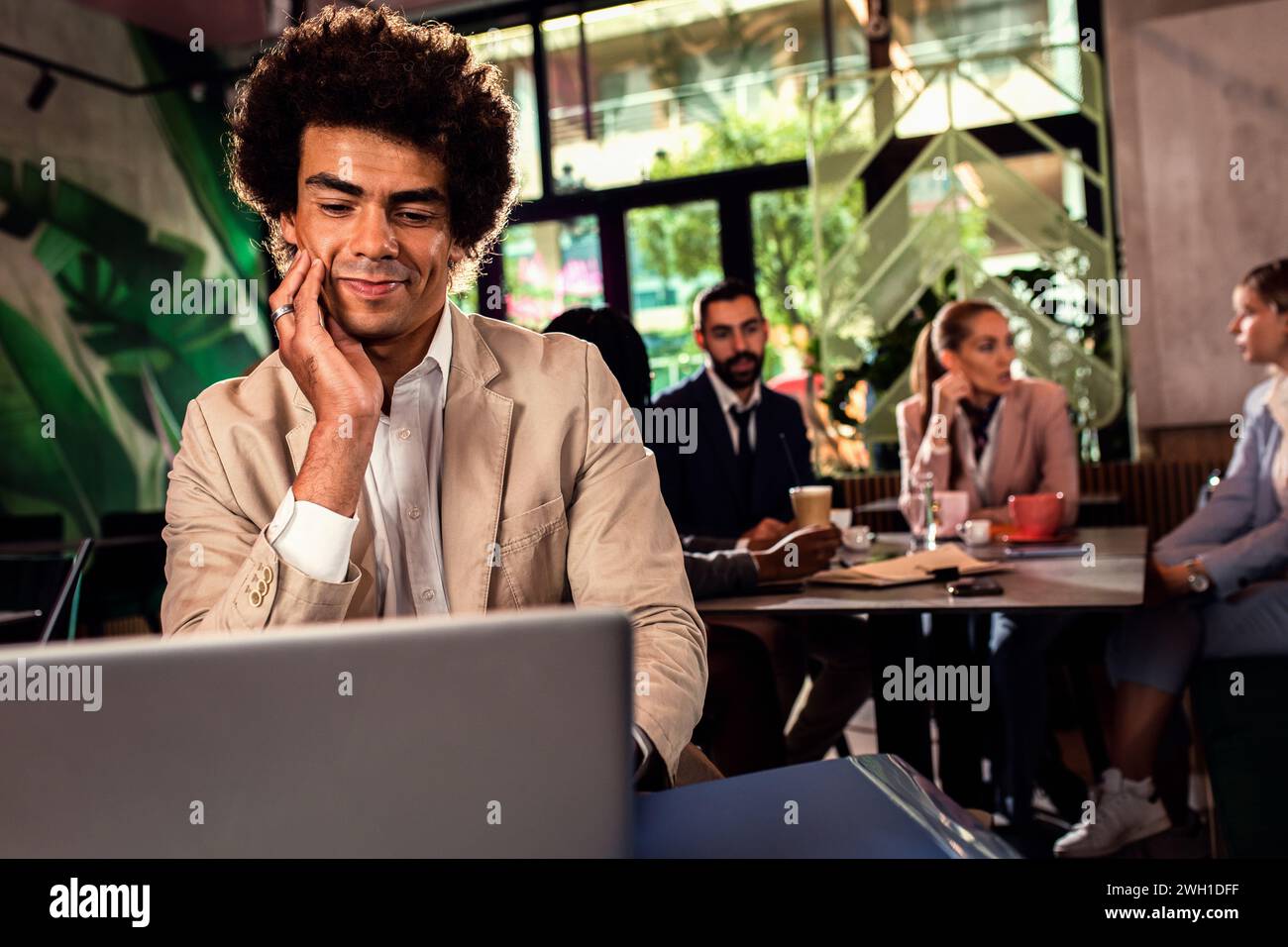Afroamerikanischer Geschäftsmann, der mit Laptop arbeitet. Stockfoto