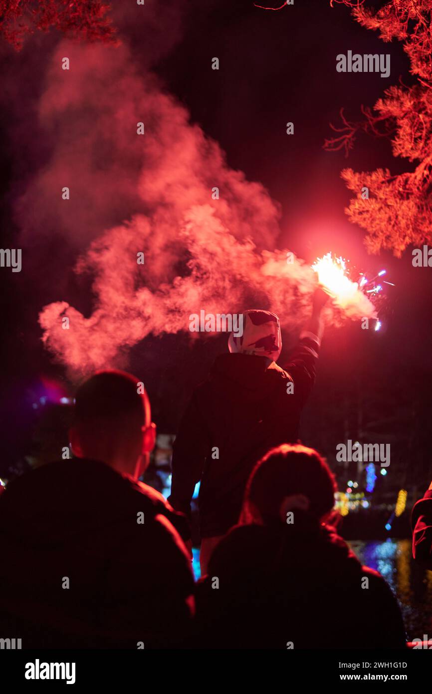 Mann hält rote Fackel mit Rauch zum Feiern Stockfoto