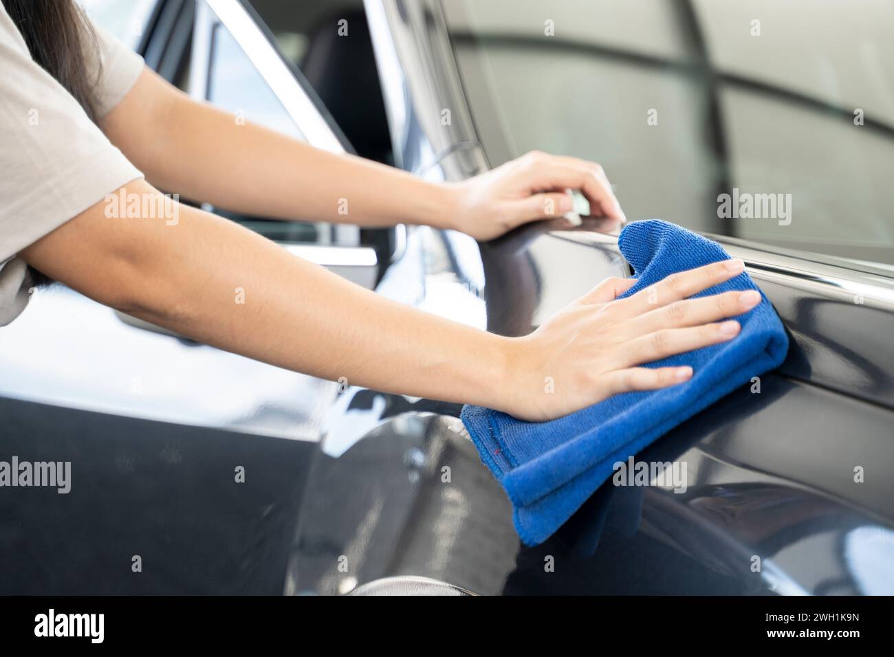 Frauen reiben das Auto mit einem Tuch. Stockfoto