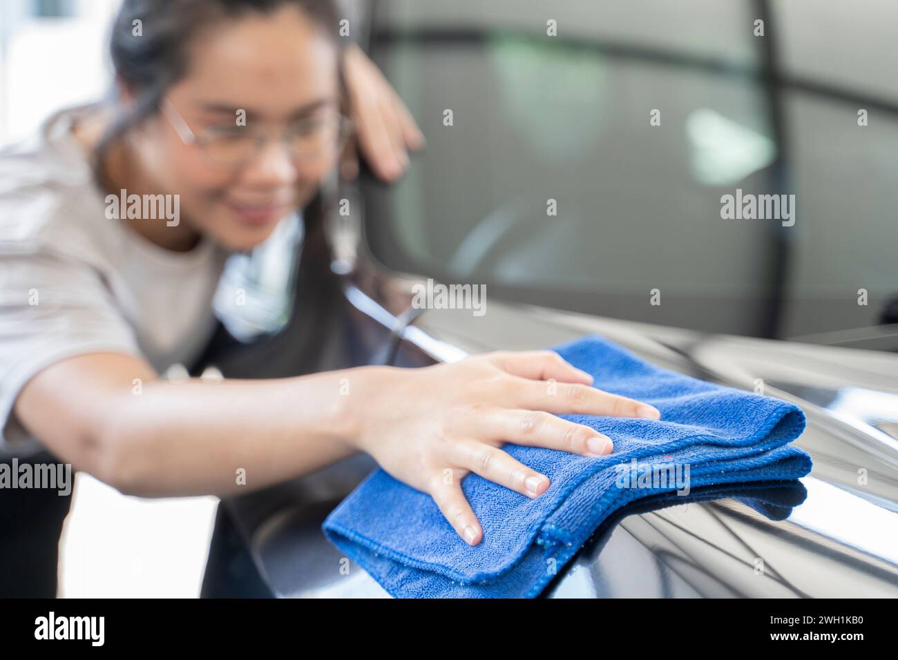 Frauen reiben das Auto mit einem Tuch. Stockfoto