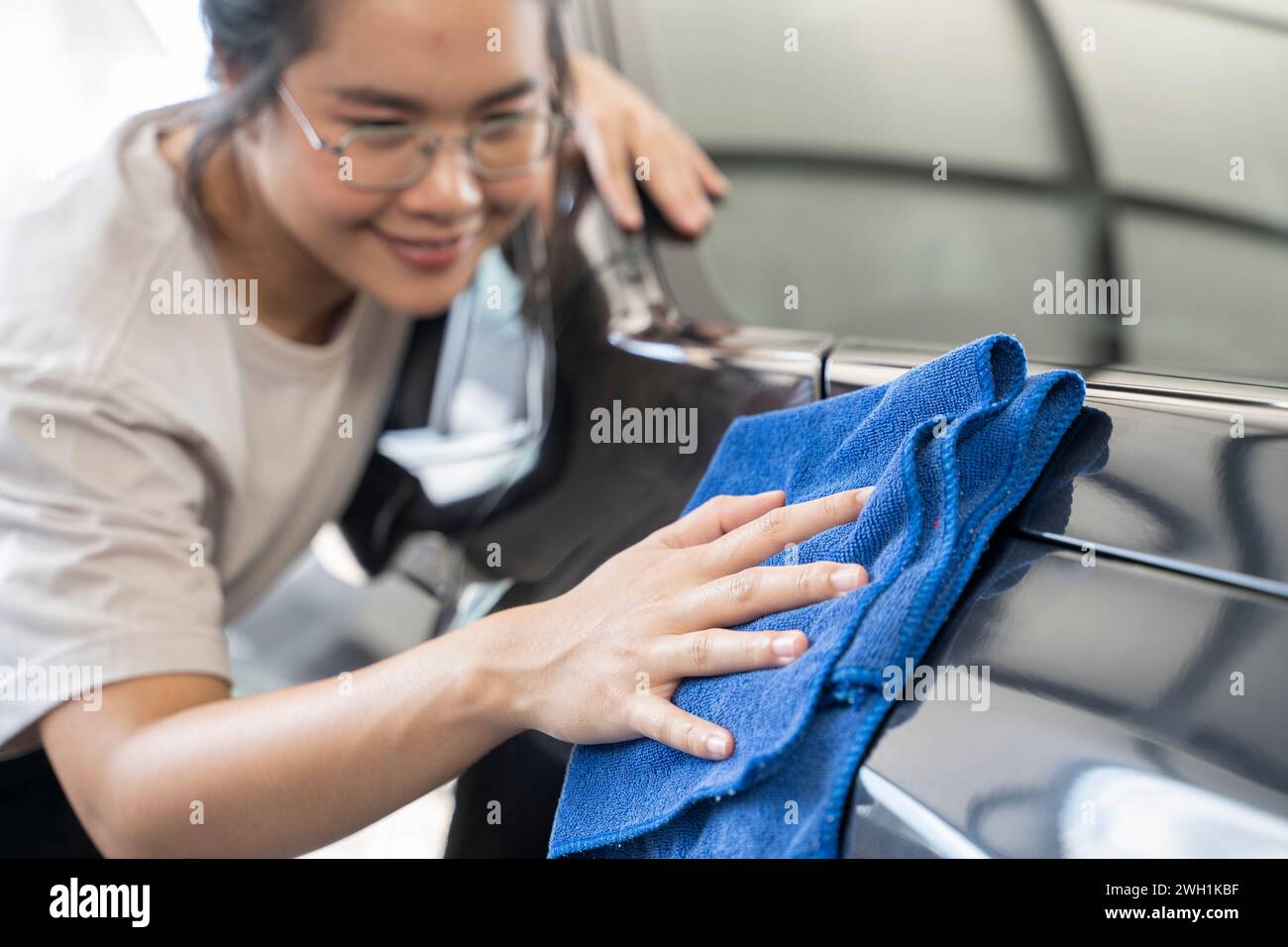 Frauen reiben das Auto mit einem Tuch. Stockfoto