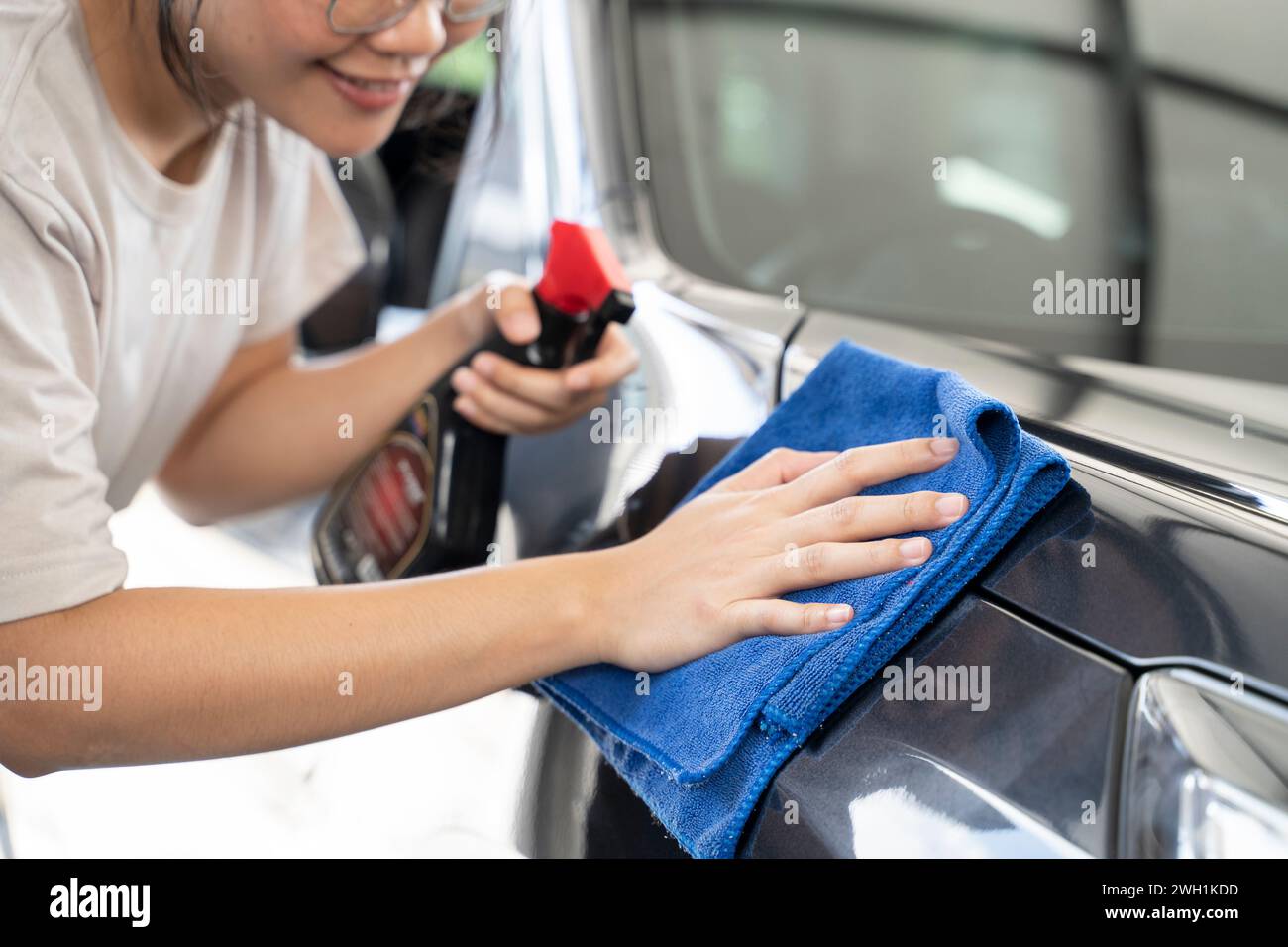 Frauen reiben das Auto mit einem Tuch. Stockfoto