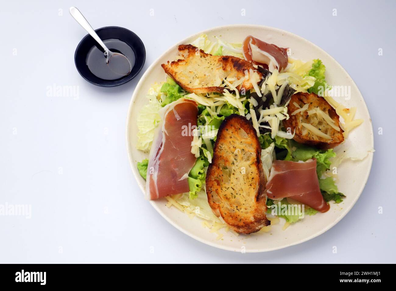 Ein Teller mit grünem Blattsalat, parmaschinken und Parmesankäse Stockfoto