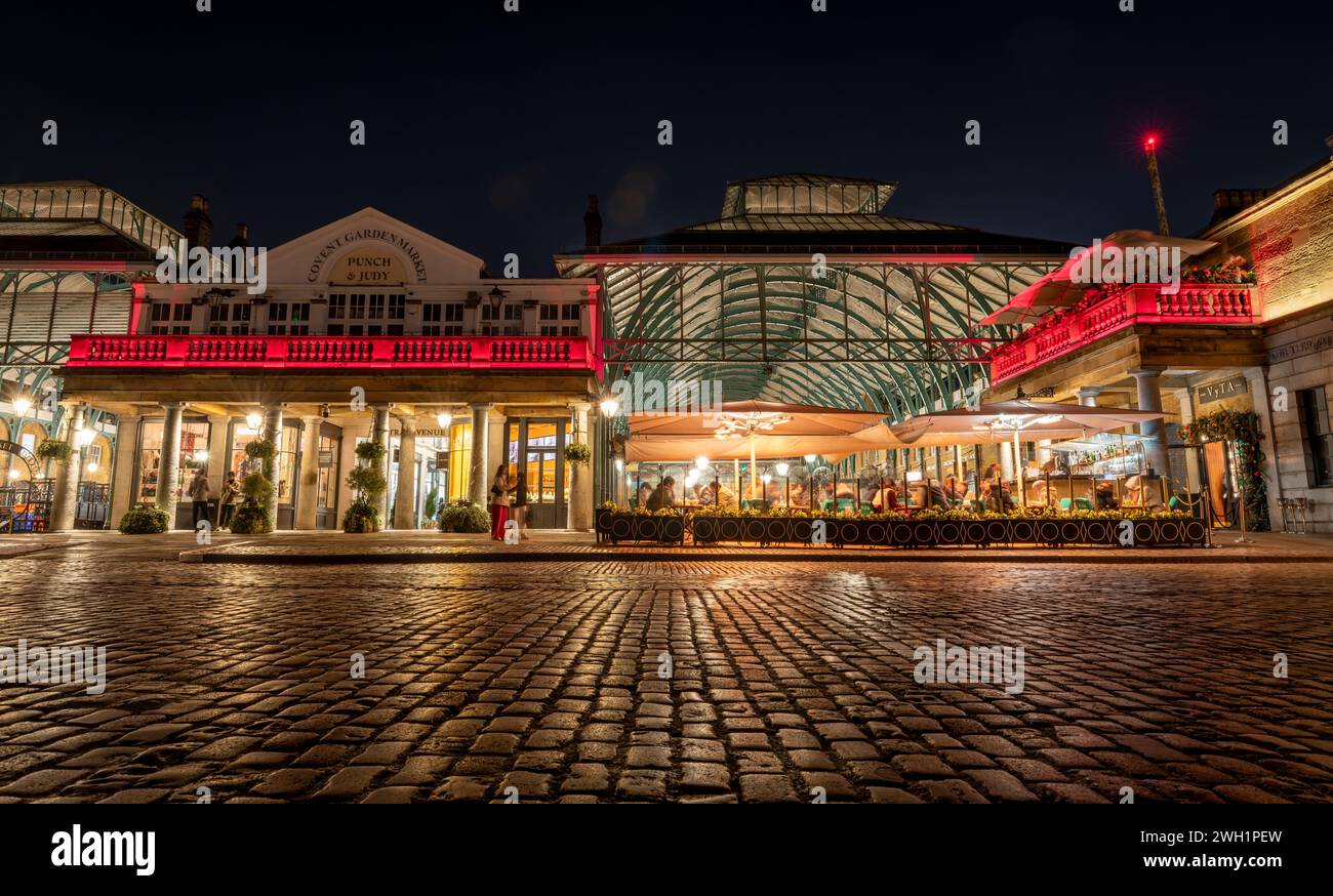 London. UK- 02.04.2024. Ein flacher Außenblick auf Covent Garden bei Nacht, der die Pflastersteinpflaster und die Gebäudestrukturen zeigt. Stockfoto