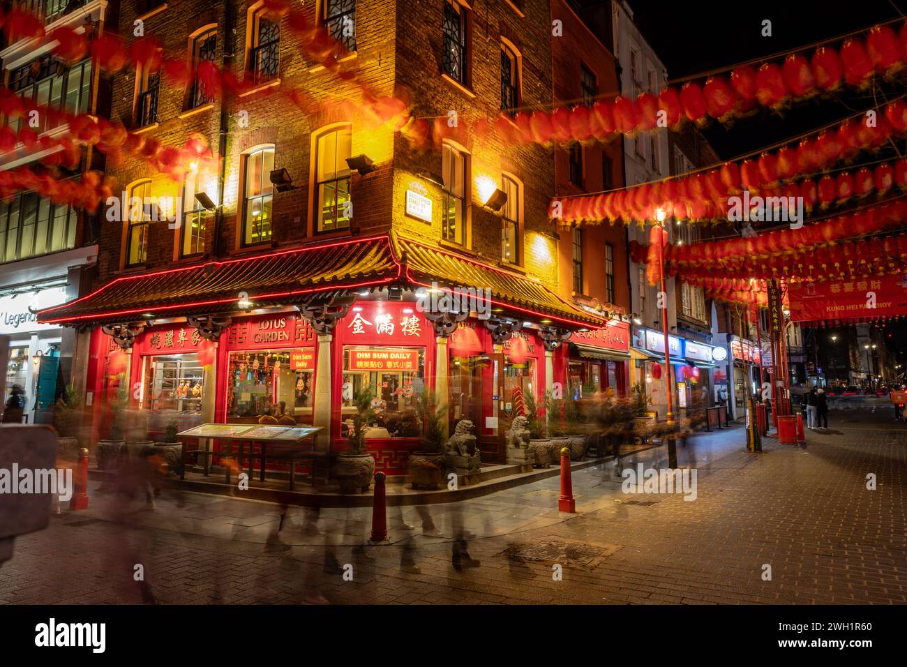 London. UK- 02.04.2024. Eine Langzeitbelichtung bei Nacht von China Town, die eines der vielen Restaurants zeigt und mit farbenfrohen Laternen für Th dekoriert ist Stockfoto