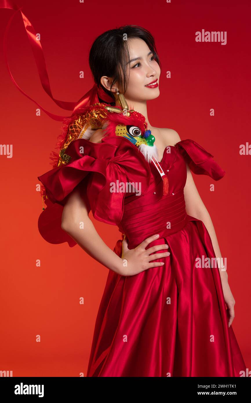 Neujahrsstimmung, eine junge asiatische Frau vor rotem Hintergrund Stockfoto