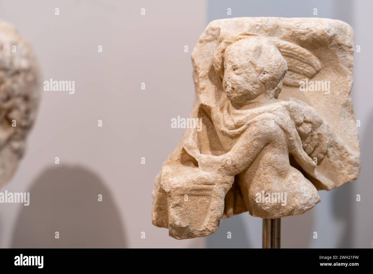 Nahaufnahme eines in Stein gemeißelten Stücks einer antiken Skulptur, die einen kleinen Engel darstellt Stockfoto