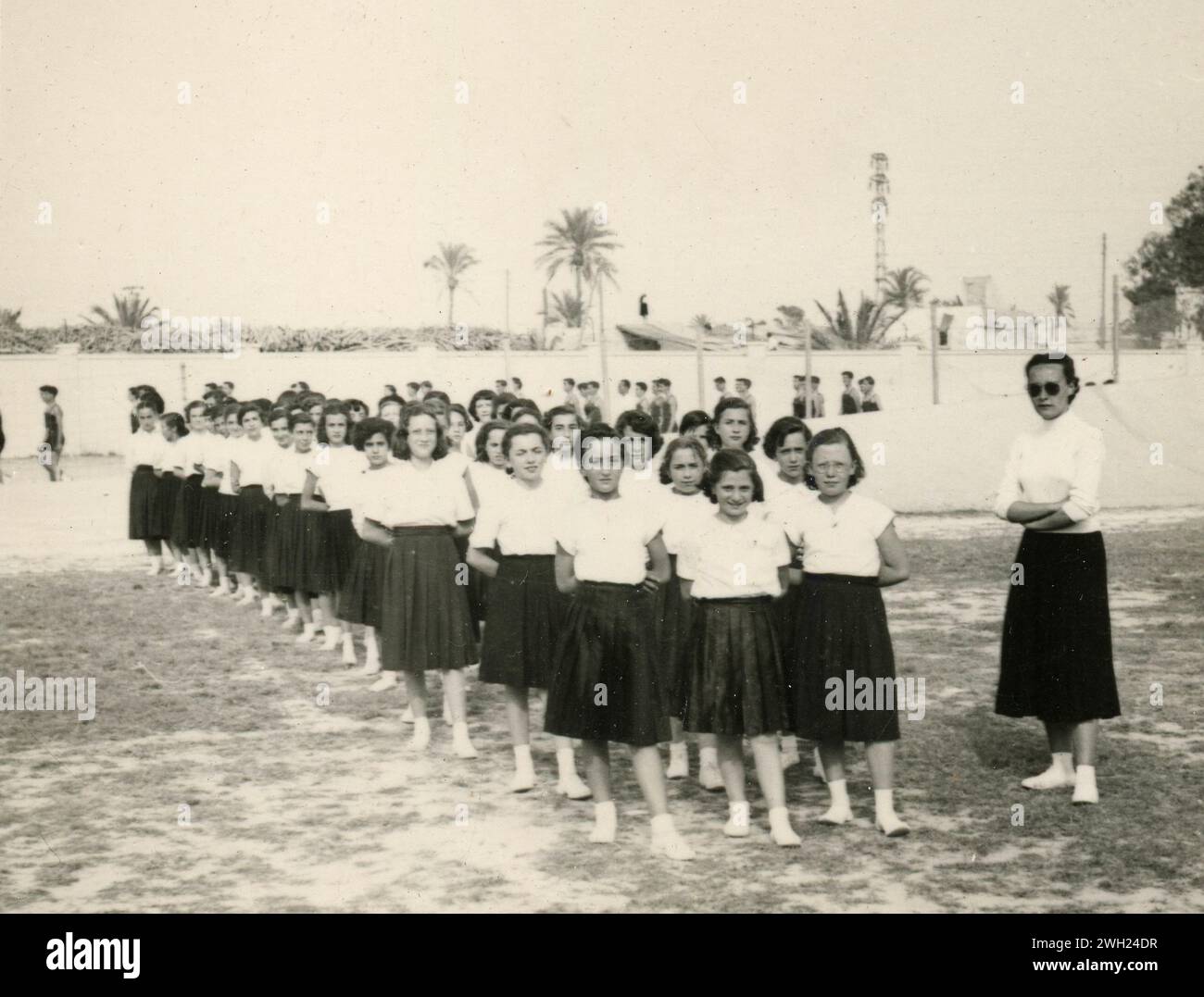 Junge uniformierte Mädchen in Schlangen im Sommerkolonielager, Italien 1930er Jahre Stockfoto