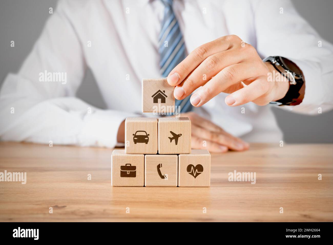 Geschäfts- oder Hausversicherung mit Holzblöcken und mehreren Versicherungssymbolen Stockfoto