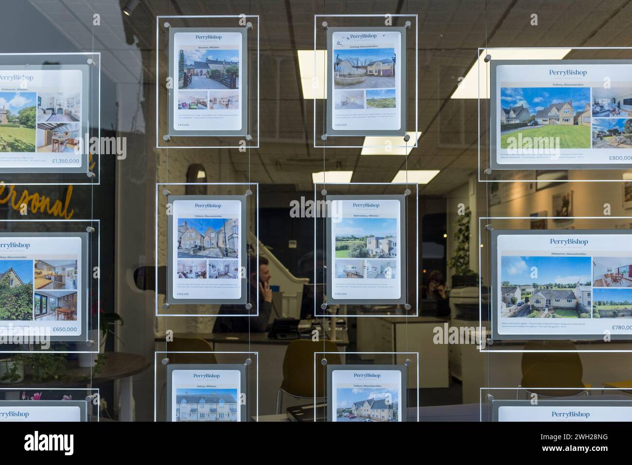 Fenster des Immobilienmaklers mit Bildern von Häusern zum Verkauf, Tetbury, Gloucestershire, Großbritannien Stockfoto