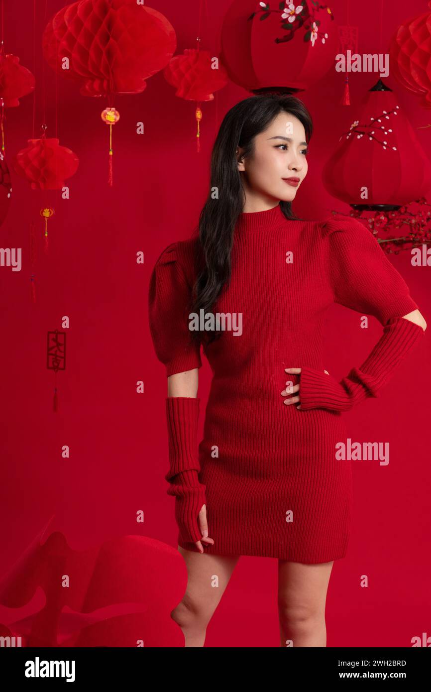 Neujahrsstimmung, eine junge Asiatin feiert das neue Jahr vor rotem Hintergrund Stockfoto