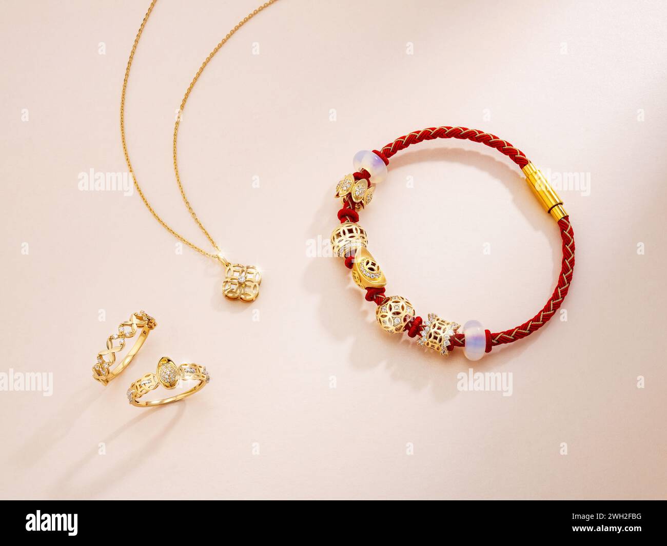 Elegante Armbänder mit rotem Charme und Goldschmuck verbinden Tradition und modernen Luxus – ideal für Geschenke oder festliche Kleidung. Stockfoto