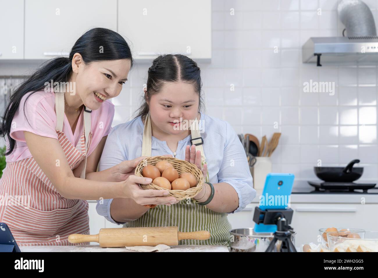 Eine Mutter und ihre Tochter genießen einen Online-Kochkurs in der Küche zu Hause Stockfoto