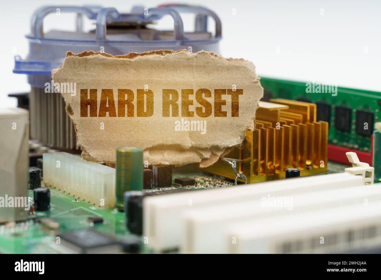 Auf der Hauptplatine des Computers befindet sich eine Pappe mit der Aufschrift - Hard Reset. Computerkonzept. Stockfoto