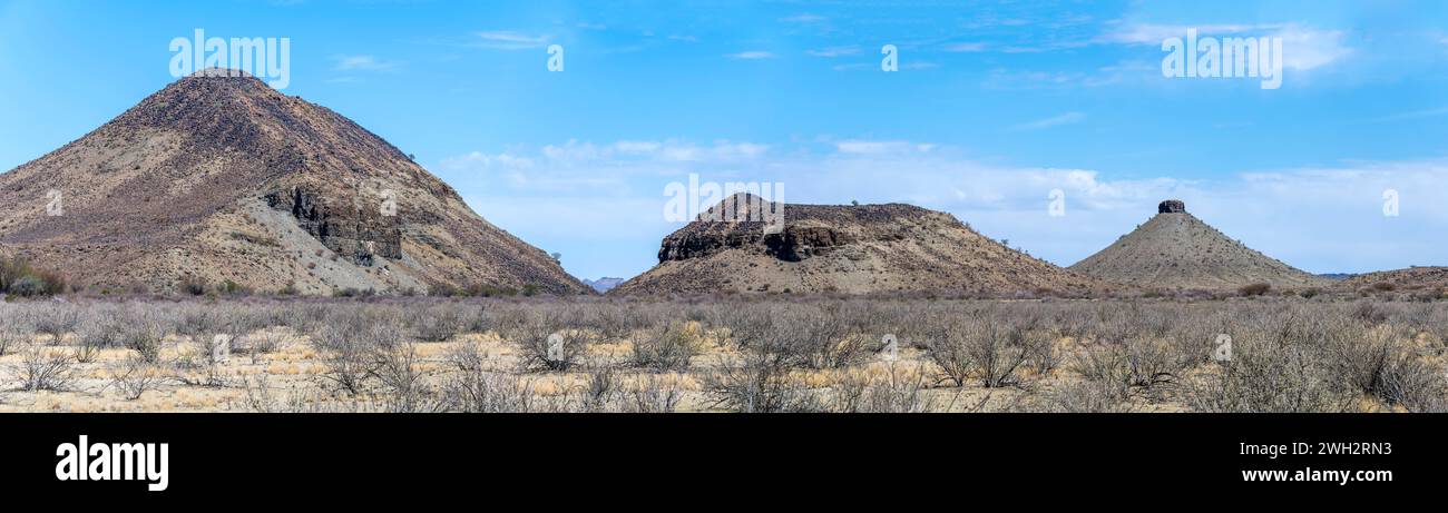 Landschaft mit Basaltkippen in karger Wüste, aufgenommen im hellen Licht des späten Frühlings in der Nähe von Gobas, Namibia, Afrika Stockfoto