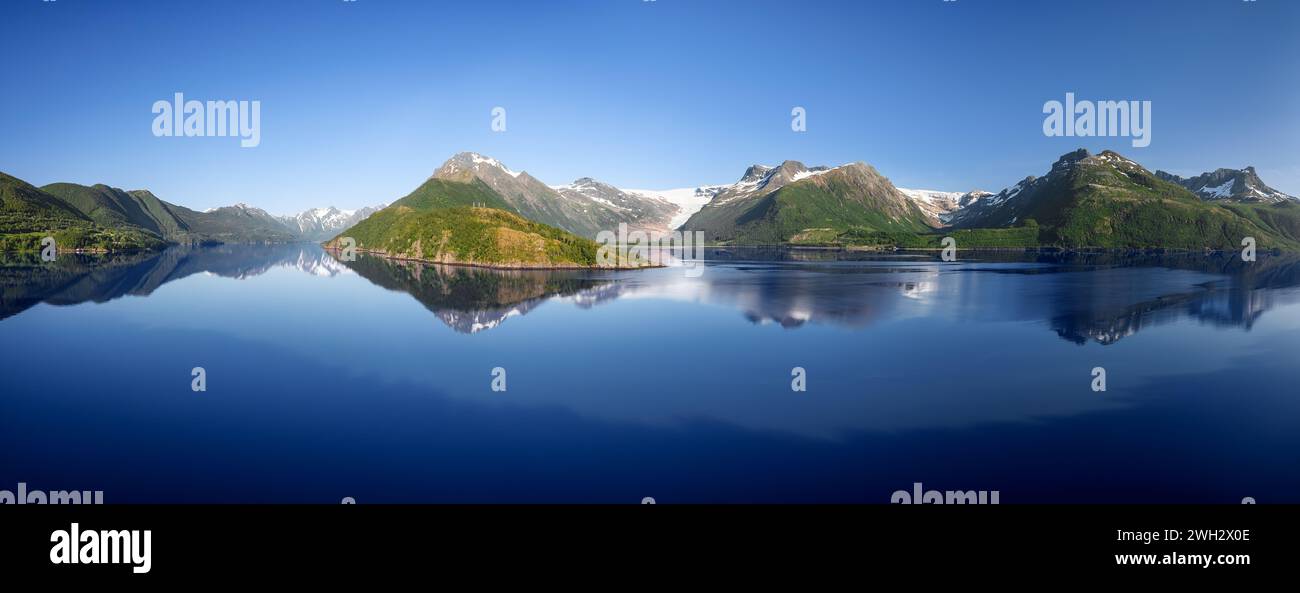 Sommer-Superpanorama, das die heitere Schönheit des norwegischen Svartisen-Gletschers in der Saltfjell-Bergkette mit spiegelähnlichem Fjordwasser und lus einfängt Stockfoto