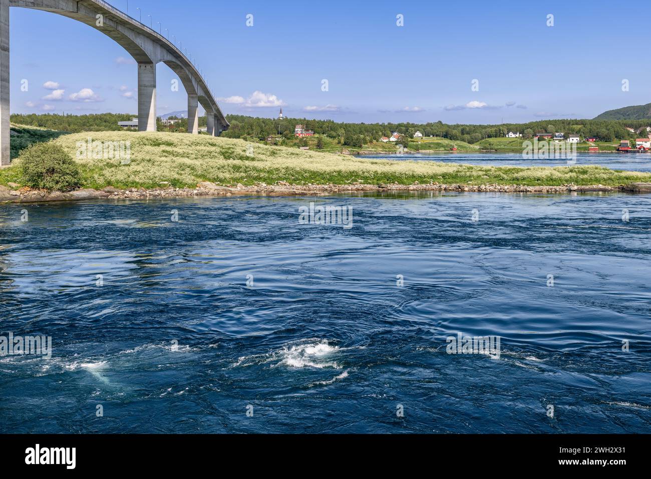 Eine Nahaufnahme der mächtigen Strömungen von Saltstraumen, die einen Teppich aus Texturen auf der Wasseroberfläche weben, im Kontrast zum anmutigen Bogen der Brücke Stockfoto