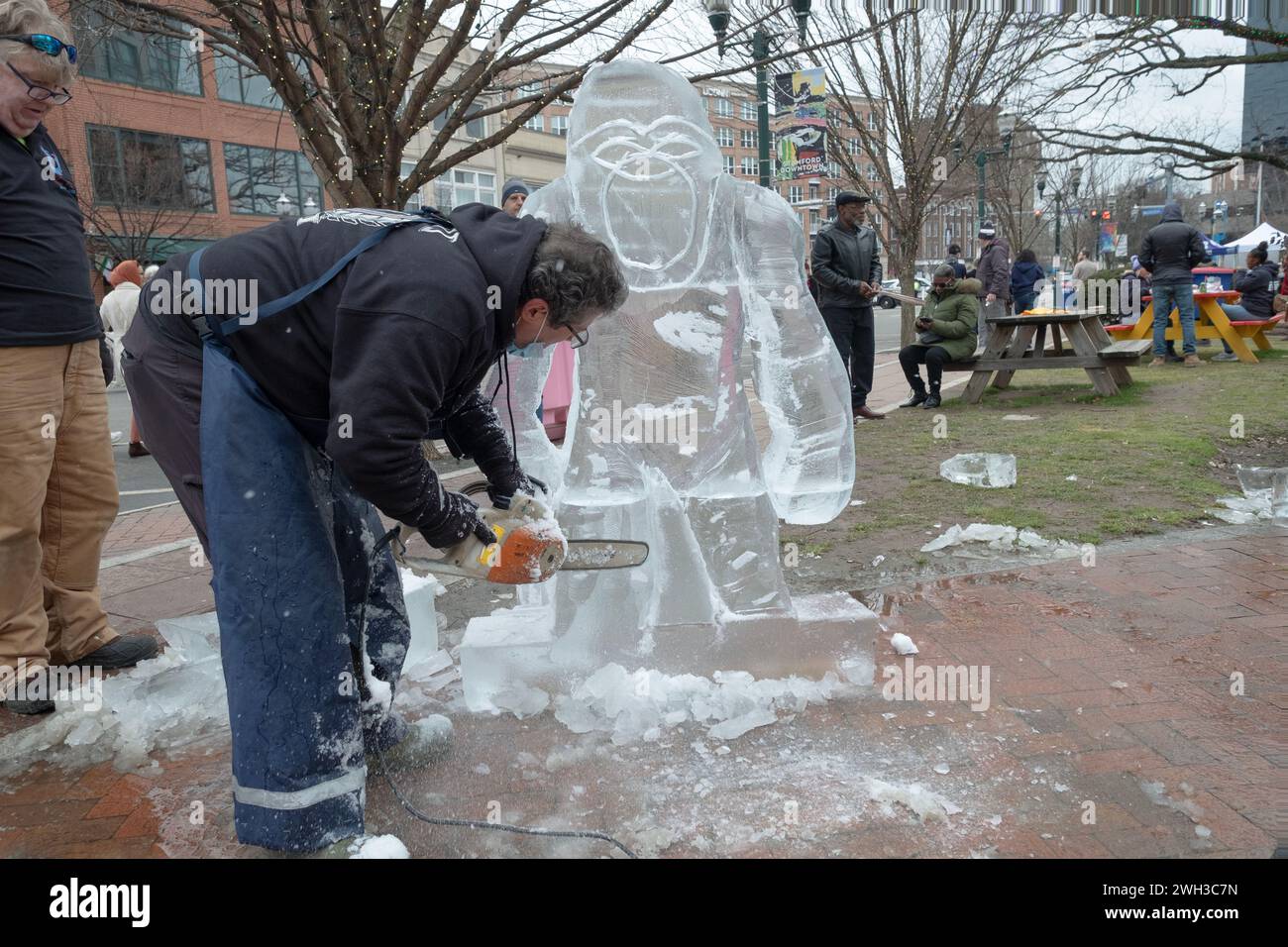 Jimmy Chiappa, Eisbildhauer, schneidet mit einer Kettensäge einen Gorilla aus Eisblöcken. Beim Fire Ice Festival im Columbus Park in Stamford, Connecticut Stockfoto