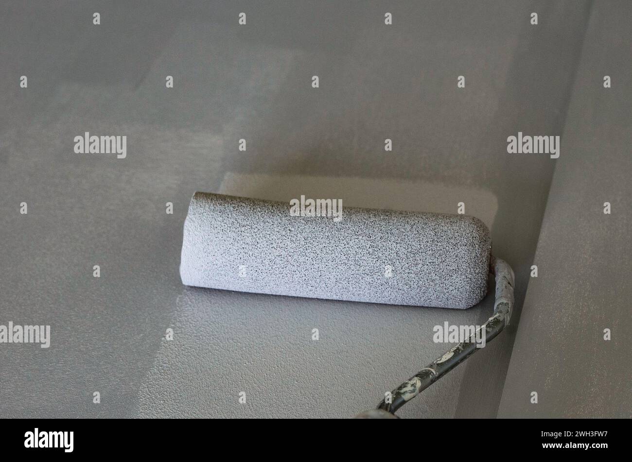 Eine Schranktür mit einer kleinen Schaum-Malwalze unterstreichen Stockfoto