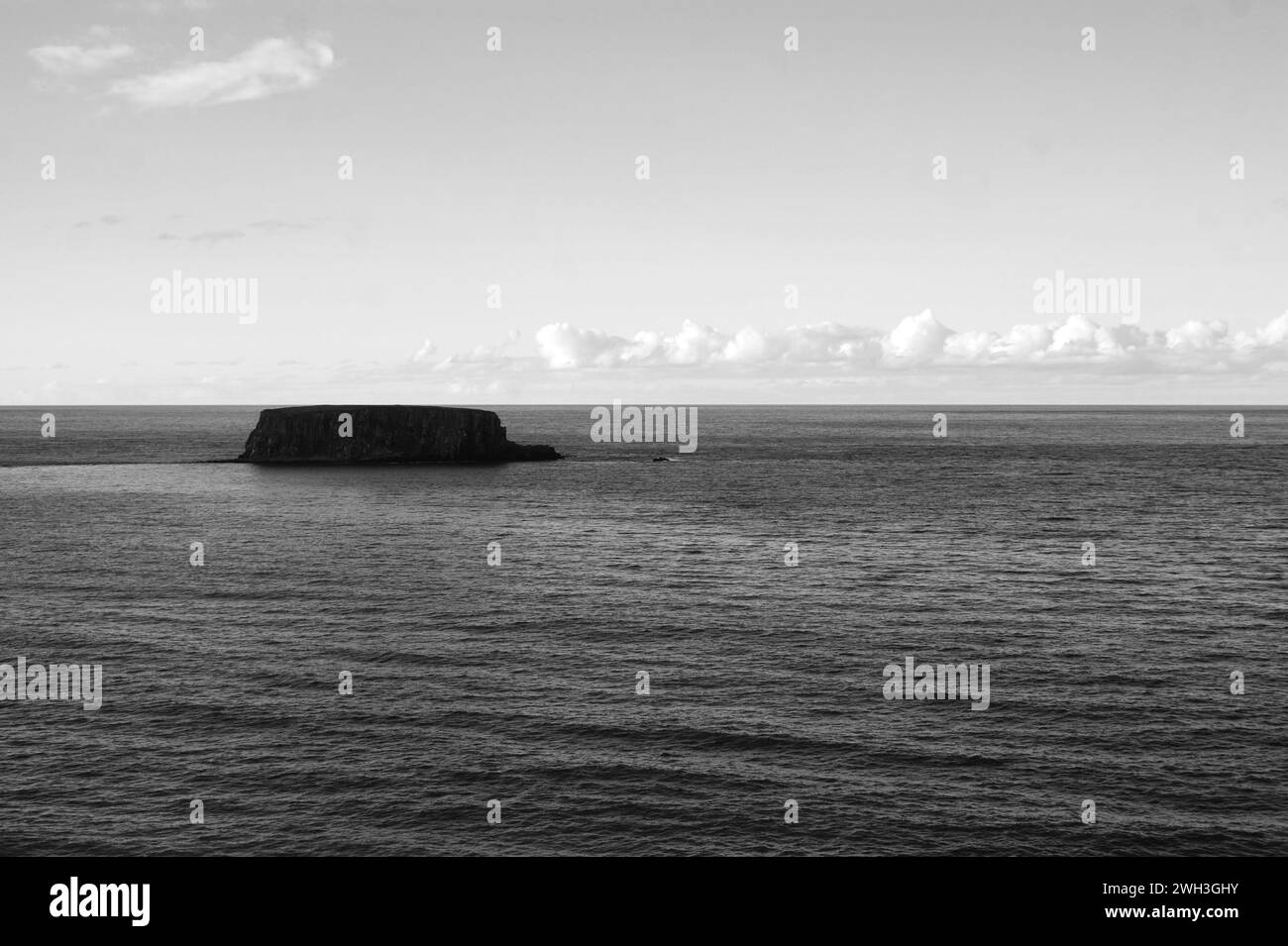 Eine kleine Insel im Meer in Nordirland, Schwarzweißfoto Stockfoto