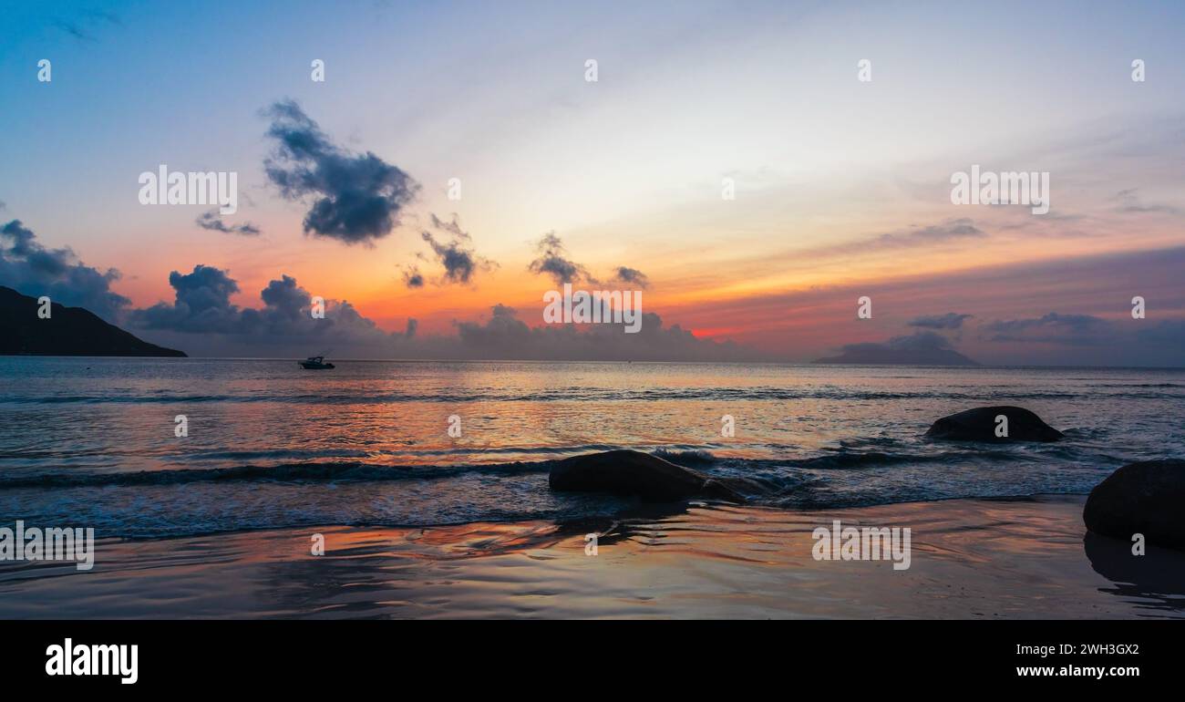 Panorama Beau Vallon Strandlandschaft mit Küstenfelsen bei Sonnenuntergang. Mahe Island, Seychellen Stockfoto
