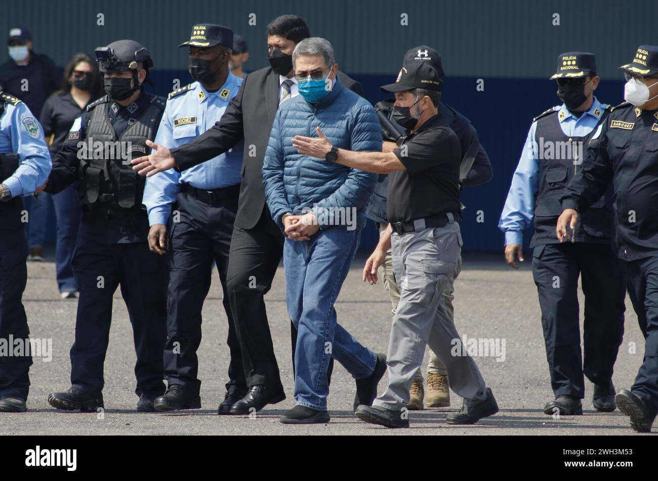 FILE - Former Honduran President Juan Orlando Hernandez, center, is taken in handcuffs to a waiting aircraft as he is extradited to the United States to face drug trafficking charges at an Air Force base in Tegucigalpa, Honduras, April 21, 2022. Hernandez's trial in New York starts Monday, Feb. 12, 2024. (AP Photo/Elmer Martinez, File) Stockfoto
